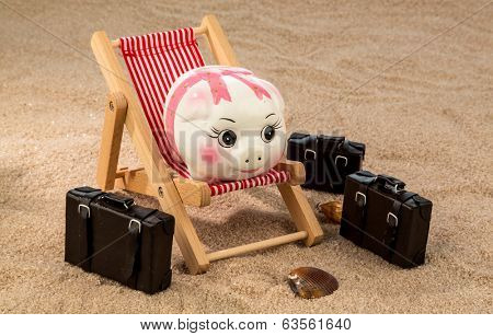 a piggy bank is located in a deck chair. symbolic photo for travel and low cost vacation