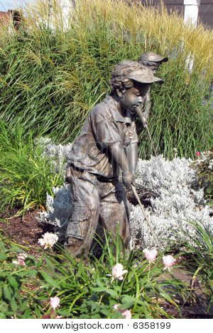 Sochařská kompozice - dva kluky hrát golf na trávě