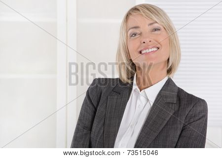 Attractive smiling middle aged businesswoman in portrait wearing business outfit.