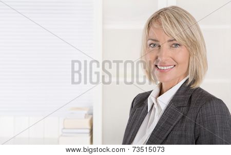 Attractive smiling middle aged businesswoman in portrait wearing business outfit.