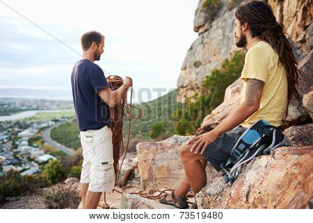 Friends preparing to go rock climbing and untangling the rope