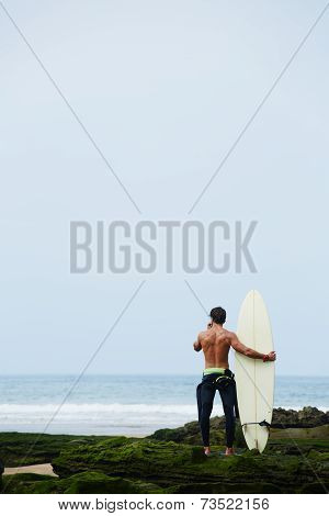 Surfer holding his favorite surfboard looking for the ocean waiting big waves