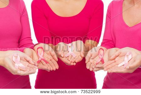 healthcare, people and medicine concept - close up of women in blank shirts with pink breast cancer awareness ribbons over white background