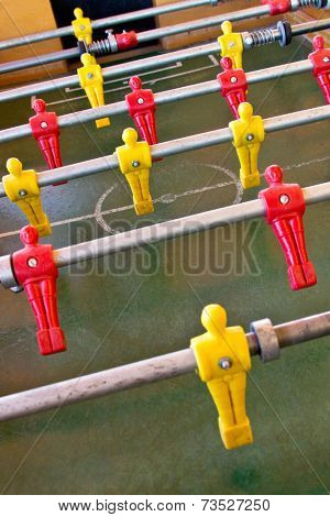Foosball is a a game in which opponents on either side of a purpose-built table attempt to strike a ball into the other side's goal. Game played often in bars and game rooms.