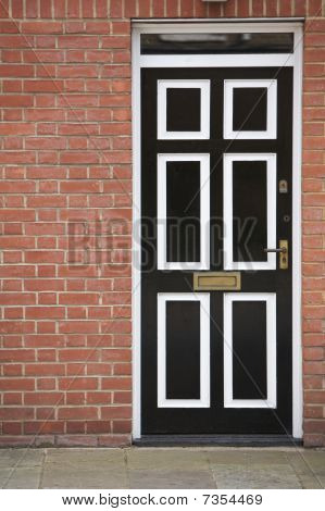 ประตูสีขาวดำกับกำแพงอิฐ