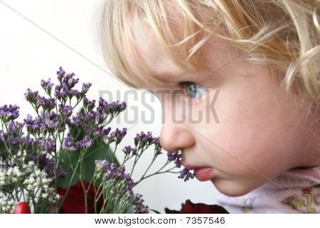 Niña que huele a flores