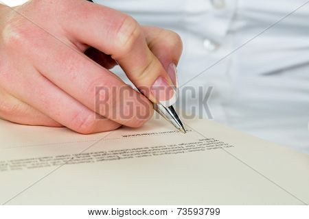 a woman signs a contract or a will with a fountain pen.