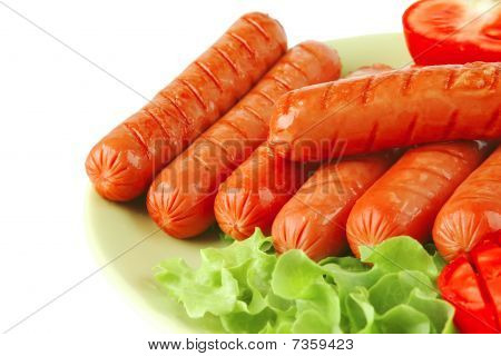Salsichas grelhadas no prato verde