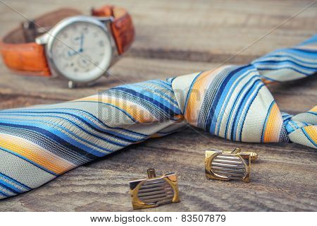 Tie, cufflinks and watches on the old wood background