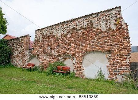 Red benches by medieval 13th century brick ruin