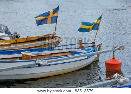 Two boats with waving Swedish flags