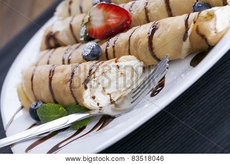 Delicious Sweet Rolled Pancakes On A Plate With Fresh Fruits