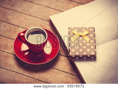 Cup Of Coffee And Gift Box With Book On A Wooden Table