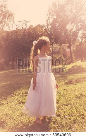 Cutel little girl wearing fairy costume enjoy summer at sunset. Toned