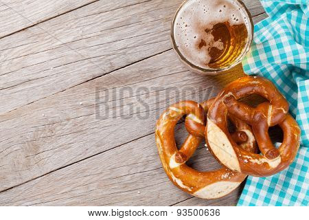 Beer mug and pretzel on wooden table. Top view with copy space