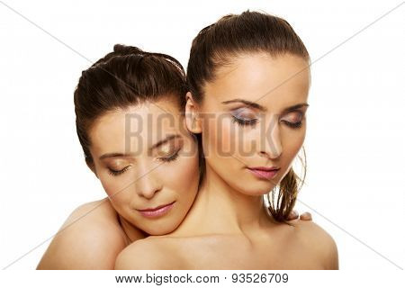 Two attractive sisters with make up and eyes closed.