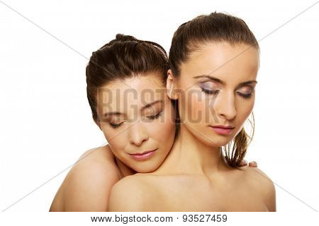 Two attractive sisters with make up and eyes closed.