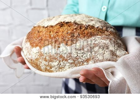 Woman holding tasty fresh bread, close up