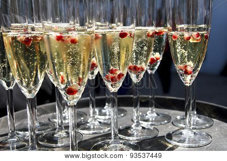 Sparkling Champagne Flutes On Tray With Pomegranate Seeds.