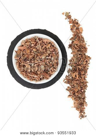 Witch hazel bark herb in a porcelain bowl and loose over slate round and white background.