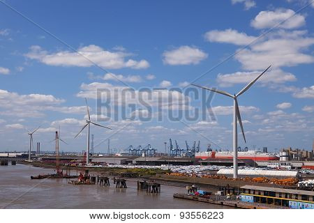 LONDON, ENGLAND - JUN 7 2015 : The Tilbury Docks wind turbines rest easy on a windless afternoon.