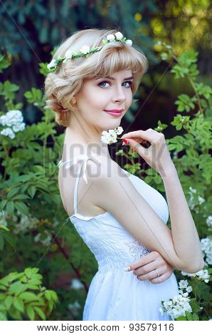 Beautiful Blonde Woman In White Sundress Posing In Garden