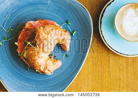 Beakfast with croissant with salmon and coffee