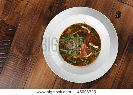Lamian (Lagman) - traditional asian soup with noodles in a plate. wooden background