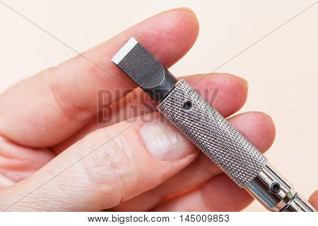 Blade Of Swivel Knife On Fingers Close Up