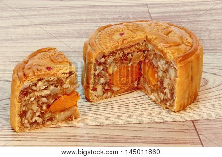 A dish of Mooncake filling five seed and salt eggs on wood. Close up focus.