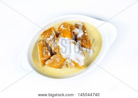 Sweet pumpkin in coconut milk on white background.
