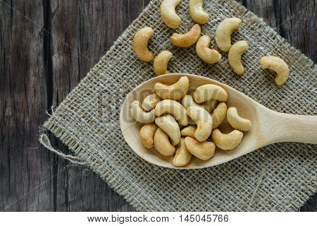 Heap of salted cashew nuts on wooden table