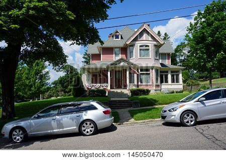 PETOSKEY, MICHIGAN / UNITED STATES - AUGUST 5, 2016: A pink Victorian mansion, with a wraparound porch, on Lake Street near downtown Petoskey.