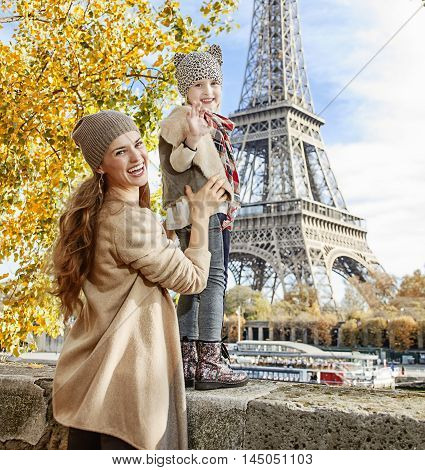 Mother And Child Travelers Handwaving On Embankment In Paris