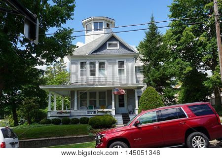 PETOSKEY, MICHIGAN / UNITED STATES - AUGUST 5, 2015: A Victorian mansion, with a wraparound porch and an observation tower, on Lake Street near downtown Petoskey.
