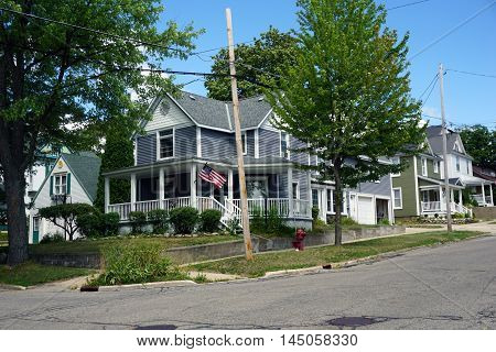 A blue Victorian mansion, with a wraparound porch, near downtown Petoskey.