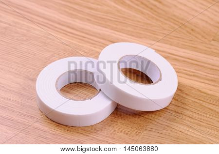 Pair roll's of double sided tape on wooden background