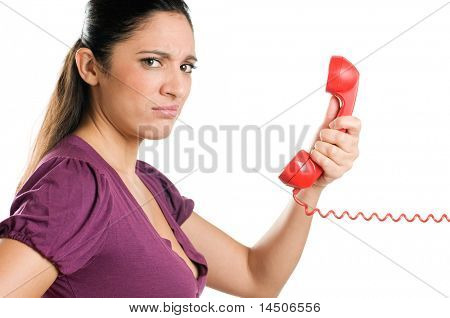 Donna giovane sorpresa guardando la telecamera con stupore durante una telefonata di un isolato sul retro bianco