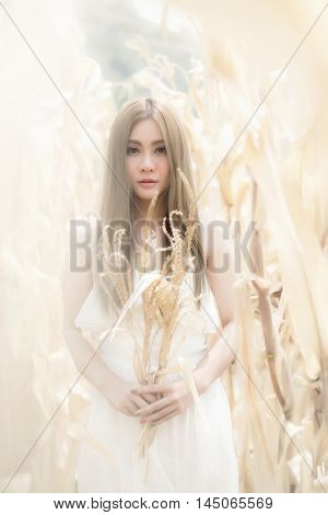 portrait of a beautiful fashion girl in white dress in golden autumn nature