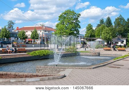 IMATRA, FINLAND - JULY 2, 2016: People near pool with fountains not far from Spa Hotel Rantasipi Imatran Valtionhotelli in the center of the town