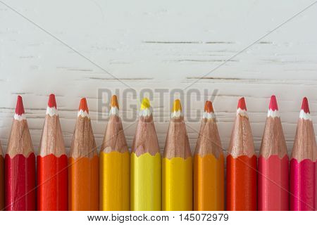 Sharp colorful crayons aligned on a white background