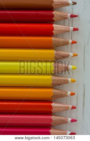 Sharp colorful crayons aligned on a white background