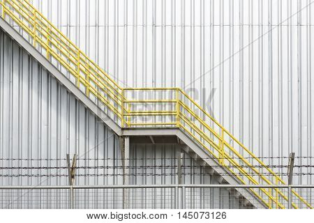 The yellow fire escape stair with the factory building background
