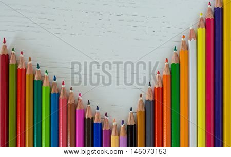 Sharp colorful crayons aligned on a white background