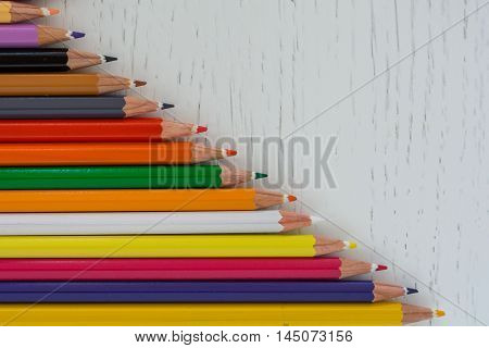 Sharp colorful crayons aligned on a white background