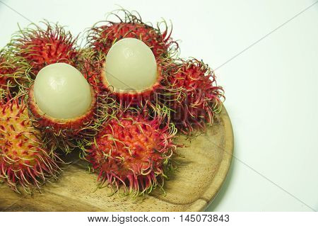 ripe Rambutan fruits on wood Craft with white background.