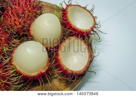 ripe Rambutan fruits on wood Craft with white background.
