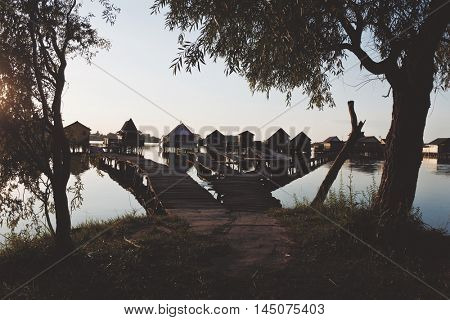 Old wooden pier, and small houses over the lake