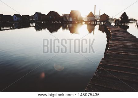 Old wooden pier, and small houses over the lake