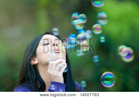 Młode piękne dziewczyny dmuchanie baniek w przyrodzie, symbol nadziei i aspiracji